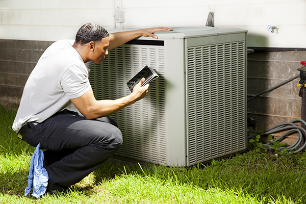 Home inspector, repairman uses digital tablet to check air conditioners.